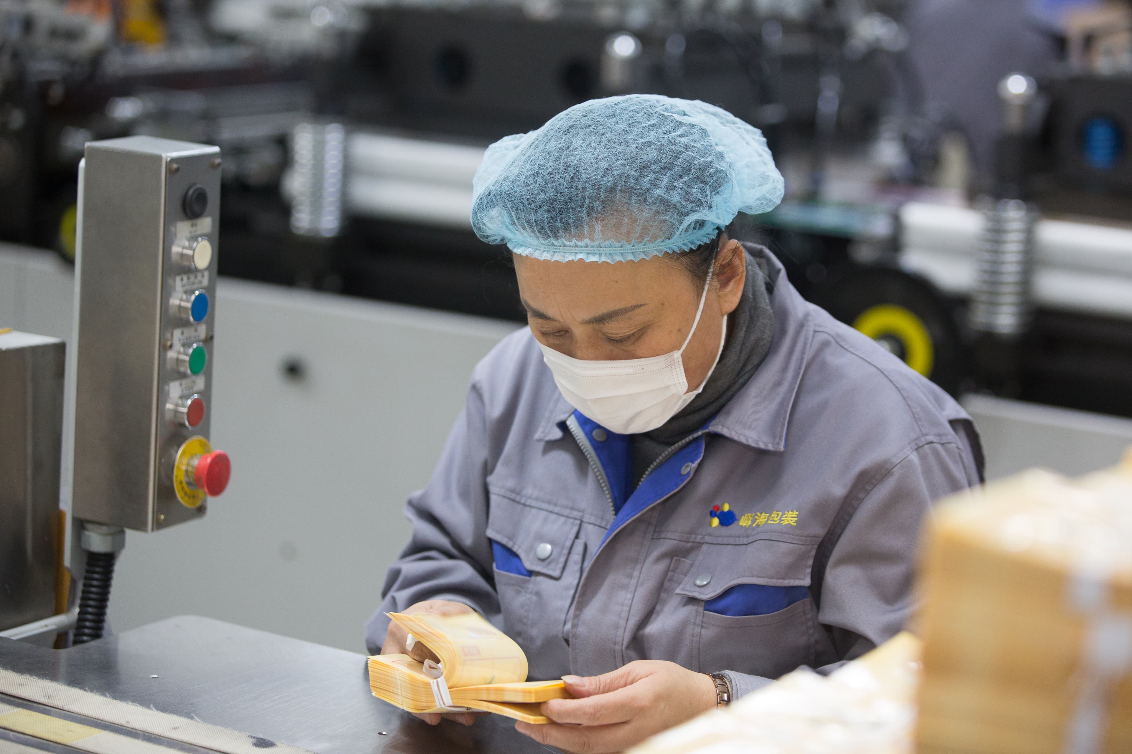A worker handling packaging on the Mylarbag production floor